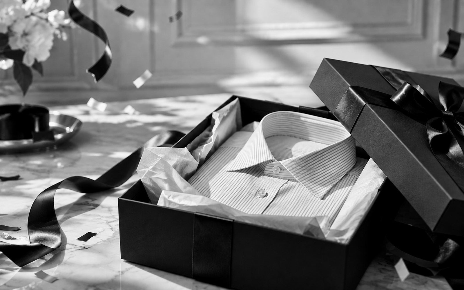 A striped shirt folded in tissue inside the black Bureau gift box